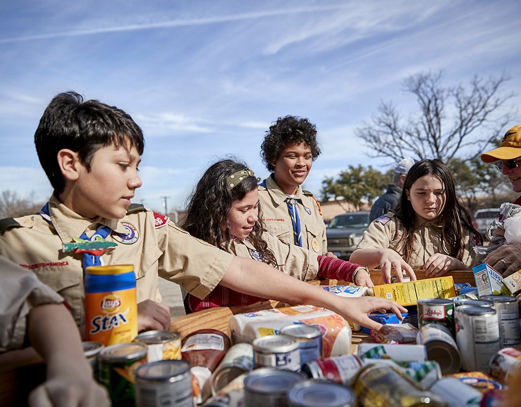 Scouts BSA sort donated food to serve their community