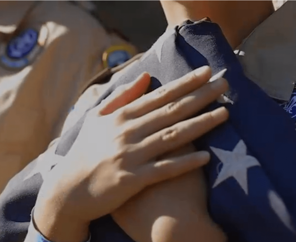 Closeup of Scouts holding a folded U.S. flag