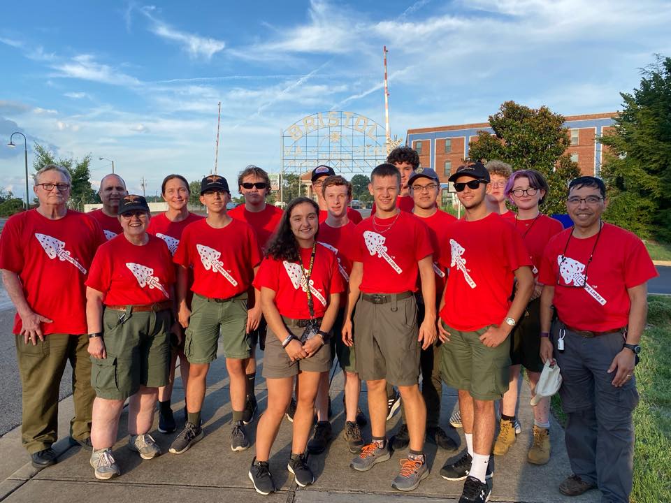 A group of happy Scouts and adult volunteers in matching red t-shirts