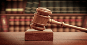 Stock image of a gavel with law books in the background.
